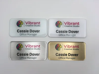 Four finished Nametag Ninja tags: gold, silver, white metal and matte plastic