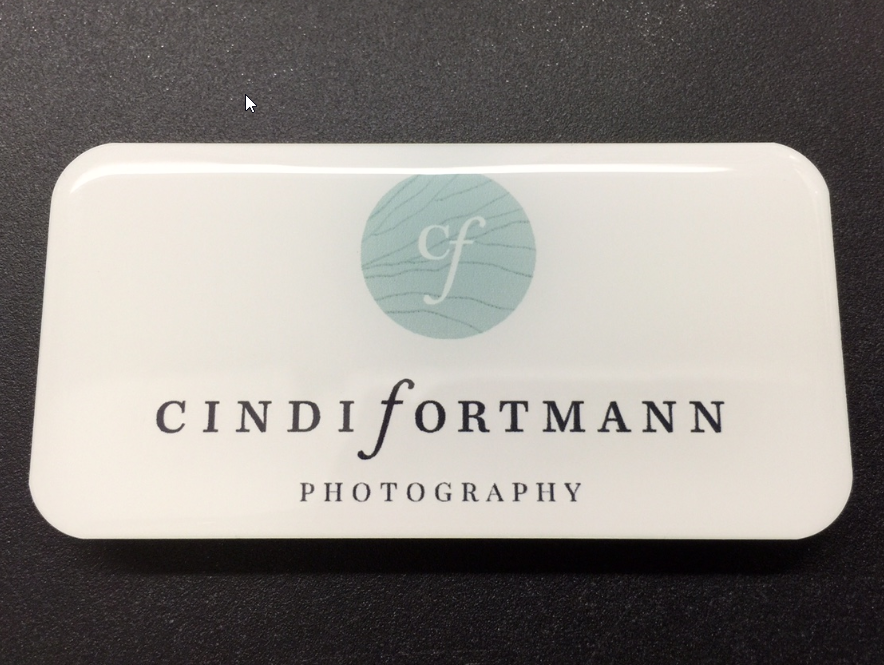 White metal nametag with epoxy coating. Design for Cindi Fortmann photography.