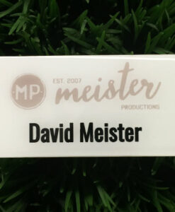 Photo of a white plastic nametag. Design for Meister Productions.