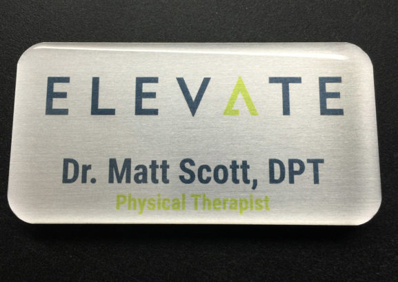 Custom brushed silver name badge. Design for Elevate.