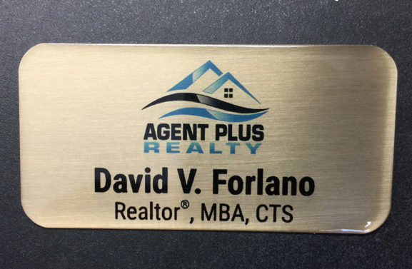 Custom brushed gold nametag with epoxy coating. Design for Agent Plus Realty.