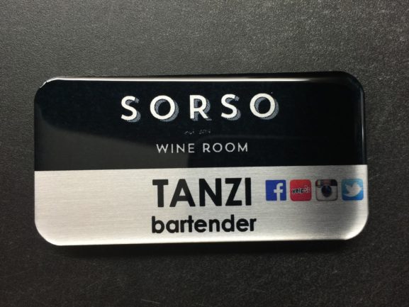 A brushed silver nametag with epoxy coating. Design is for SORSO wine room.